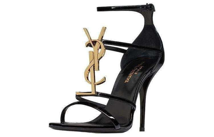 صندل كعب عالي Saint Laurent بتصميم شعار YSL ذهبي ولون أسود.