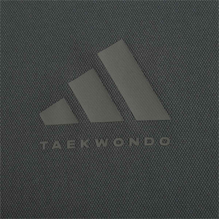 adidas logo on a dark fabric background with "Taekwondo" text.