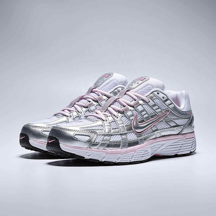 Nike P-6000 lifestyle sneakers in white, metallic silver, elemental pink, and black with a low heel design for women.