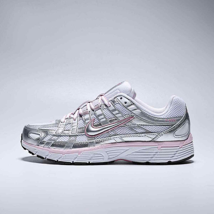 Nike P-6000 women's lifestyle shoes in white, metallic silver, elemental pink, and black with a low heel design.
