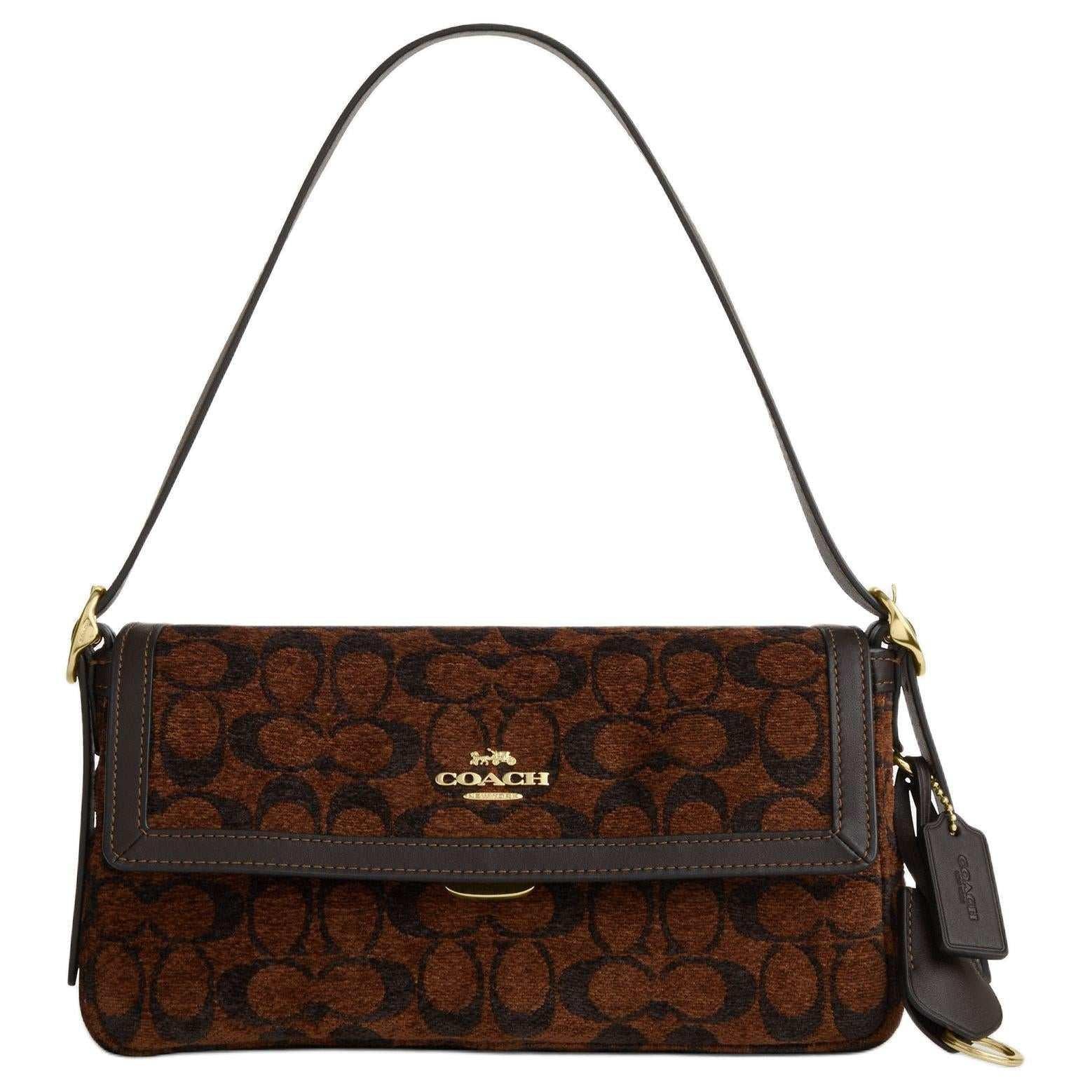 حقيبة كتف COACH بنقشة Signature المميزة باللون البني.