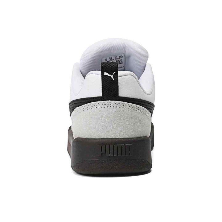 Puma sneakers, white and black with wide rubber sole, back view.