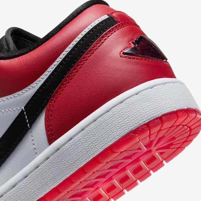 Air Jordan 1 Low in white, varsity red, and black colorway with classic leather design and rubber sole.