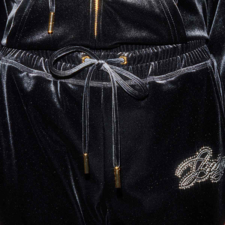 Juicy Couture black velvet pants with crystal embroidery and gold-accented drawstring.