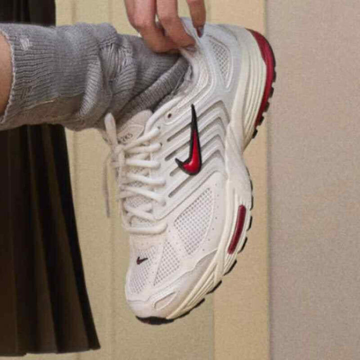Nike Air Pegasus 2006 sneaker in sail, coconut milk, and black, featuring a red Nike swoosh and cushioned sole.