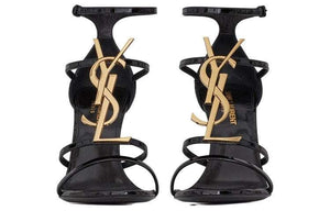 صندل كعب عالي Saint Laurent بتصميم شعار YSL ذهبي ولون أسود.