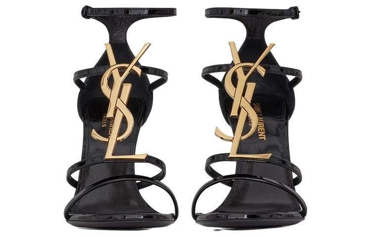 صندل كعب عالي Saint Laurent بتصميم شعار YSL ذهبي ولون أسود.