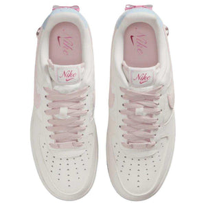 حذاء Nike Air Force 1 أبيض مزين بفيونكة وقلب وردي.