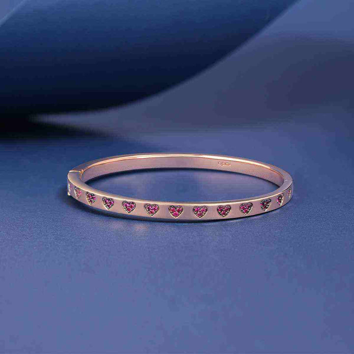 APM MONACO Love Sparkle bracelet with pink crystal hearts on rose gold background.