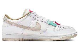 حذاء Nike Dunk Low رياضي باللون الأبيض والوردي.