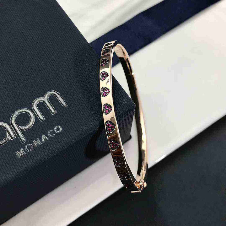APM MONACO pink heart bracelet with crystal accents on a gold-tone band.