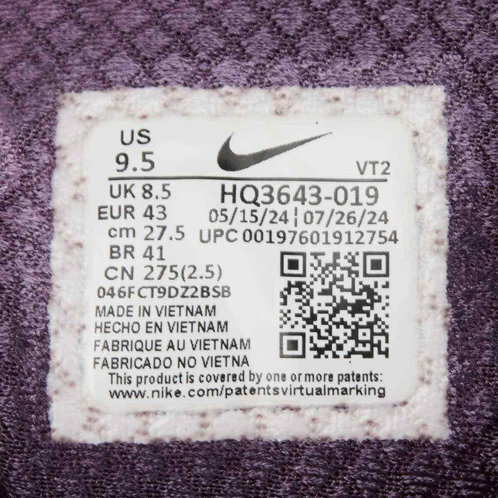 Nike ZOOM VOMERO 5 athletic shoe in lavender with label showing size and product details.