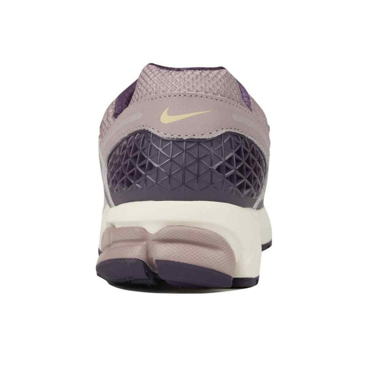 Nike ZOOM VOMERO 5 sneaker in lavender with gold logo and durable rubber sole.