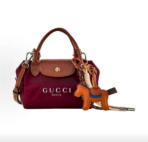 حقيبة يد GUCCI beauty صغيرة بلون عنابي مع تعليقة.