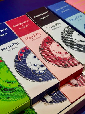 Stacked colorful luxury packaging boxes for the Audemars Piguet x Swatch Royal Pop limited edition collection.