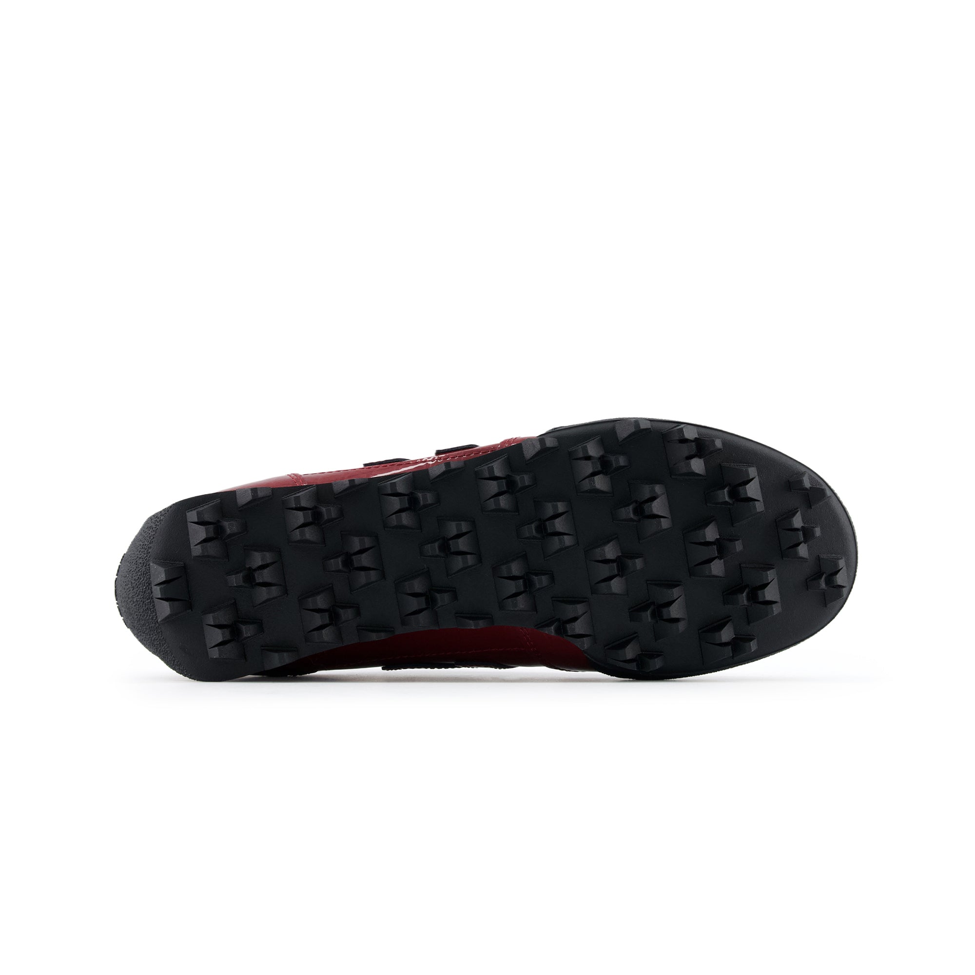 Bottom outsole view of burgundy patent leather New Balance RC30 shoes, featuring a black rubber tread pattern with exaggerated angular studs across the entire sole.