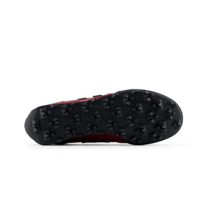 Bottom outsole view of burgundy patent leather New Balance RC30 shoes, featuring a black rubber tread pattern with exaggerated angular studs across the entire sole.