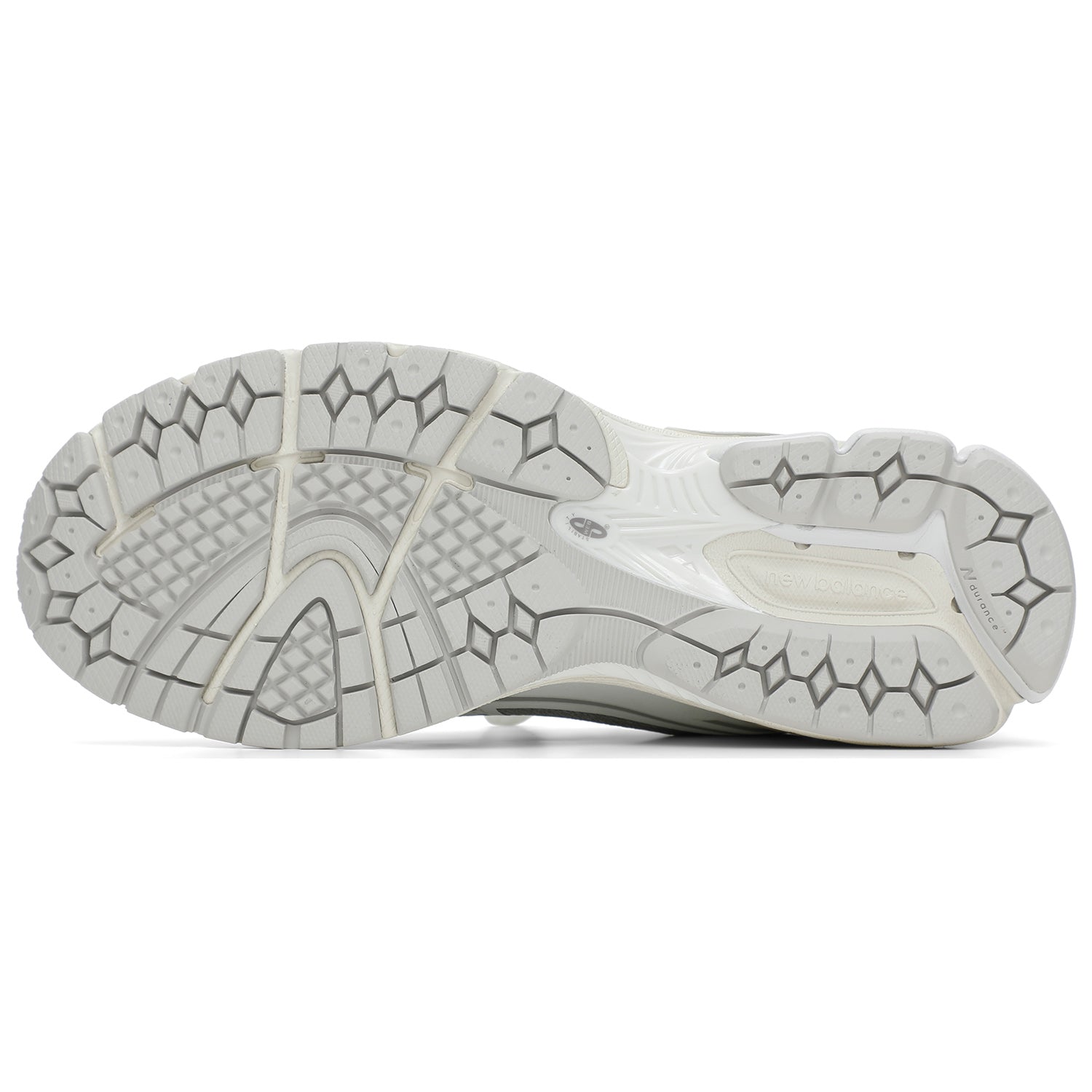 Bottom outsole view of grey and white New Balance shoes 1906R model, featuring a light grey rubber traction tread pattern, off-white flex grooves, and a white midfoot Stability Web arch support shank.