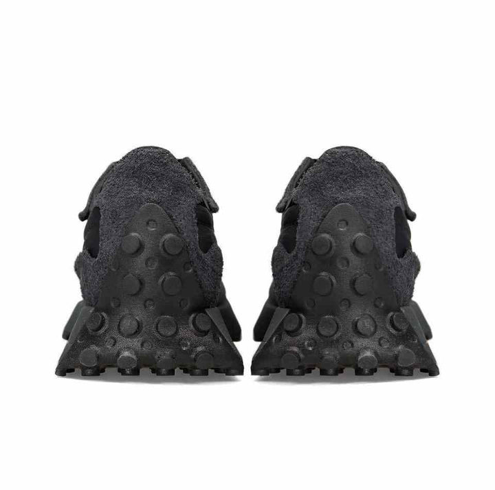 New Balance 327 sneakers, black with rubber outsole, rear view.