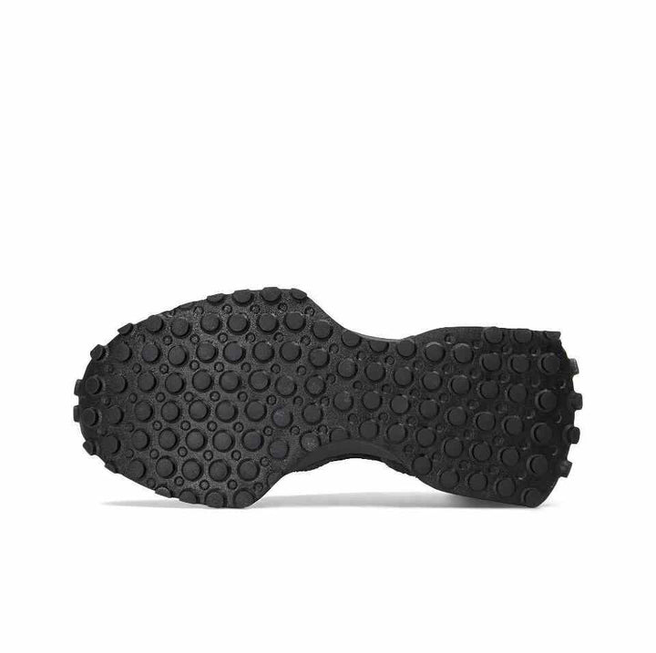 Black rubber sole of New Balance 327 sneaker.