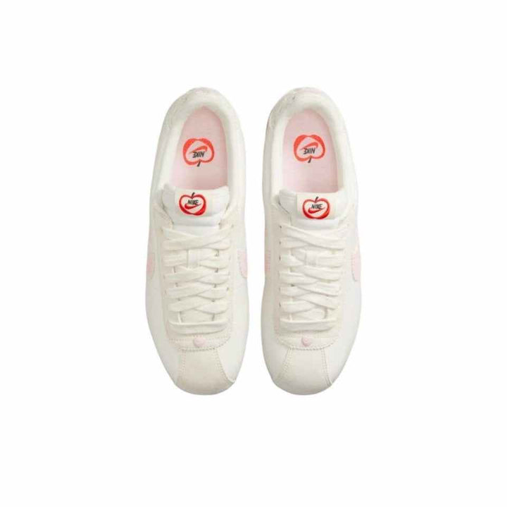 Top view of white Nike Cortez women's classic lightweight walking shoes with pink accents and lace-up design