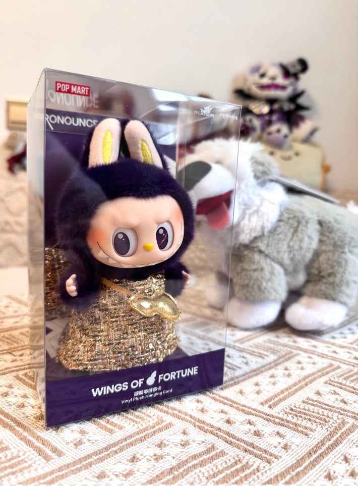 Labubu figurine in a box from Top Market with plush toy in the background.