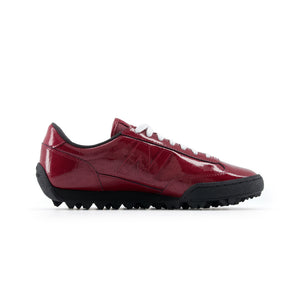 Medial side profile of burgundy patent leather New Balance RC30 shoes, featuring a glossy crocodile-embossed burgundy upper, matching patent leather N logo, white laces, black interior lining, and a black rippled studded rubber outsole.