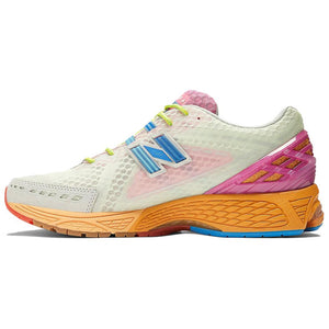 Medial side profile of multicolor light green and pink New Balance shoes 1906R model, featuring pale green mesh uppers with pink translucent side paneling, bright blue N-Lock support webbing, lime green laces, hot pink TPU heel cage, and a textured orange N-ergy cushioned midsole with blue outsole accents.