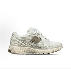 Medial side profile view of cream and off-white New Balance shoes 1906R.
