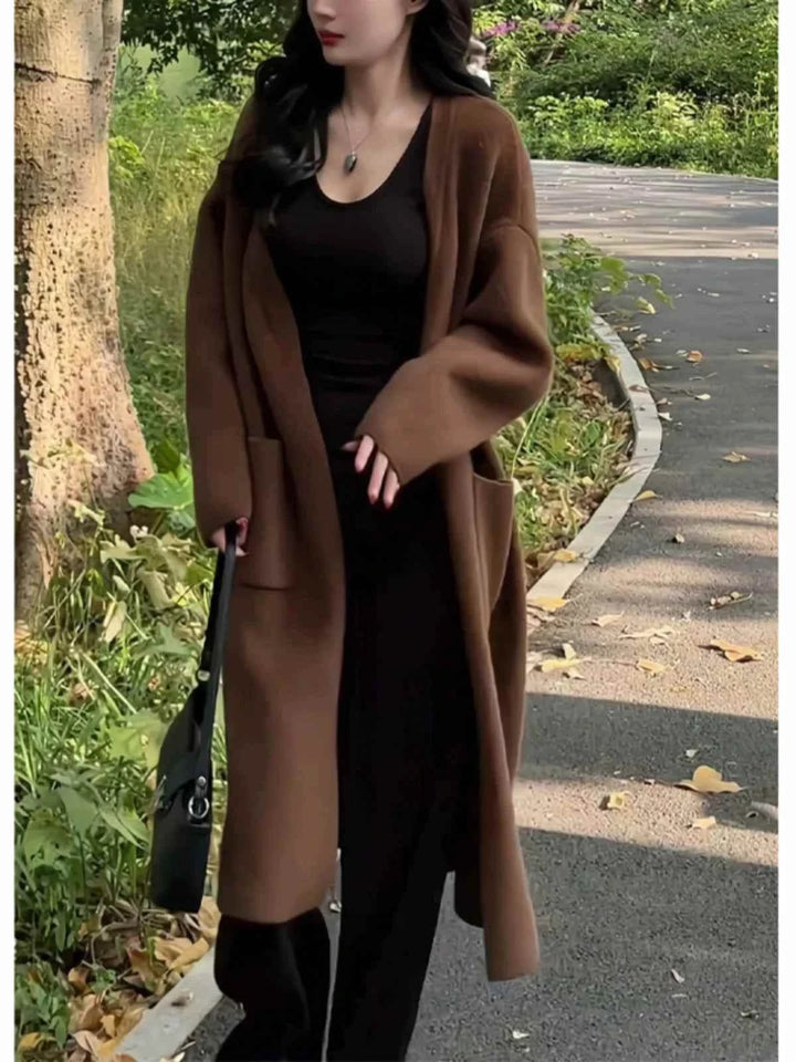 long dark brown winter cardigan for women with wide fit and pockets, soft warm fabric for cold weather, styled over black outfit outdoors
