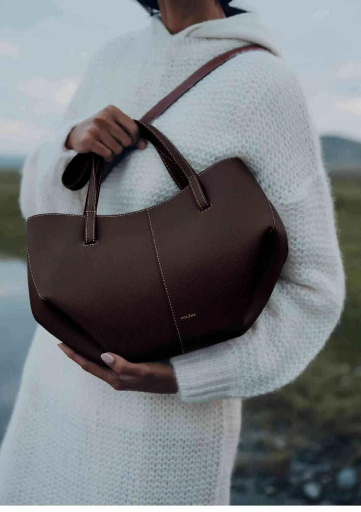 Polène Cyme Mini small brown leather tote bag with soft curves, handheld and shoulder strap options, elegant design.