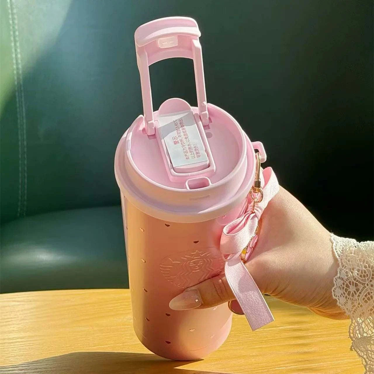 كوب Starbucks Tumbler وردي بنقشة قلوب وفيونكة أنيقة.