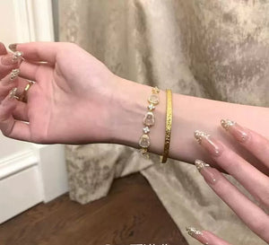 سوار نسائي ذهبي مرصع بأحجار الكريستال الأنيقة.