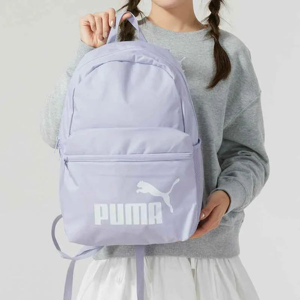 Light purple PUMA backpack with front zipper pocket and adjustable padded shoulder straps, ideal for school and daily use.