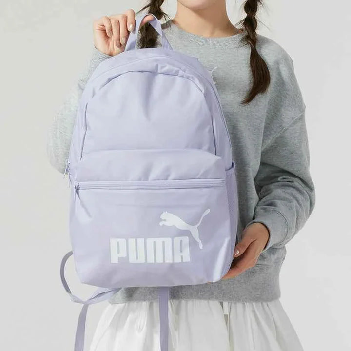 Light purple PUMA backpack with front zipper pocket and adjustable padded shoulder straps, ideal for school and daily use.
