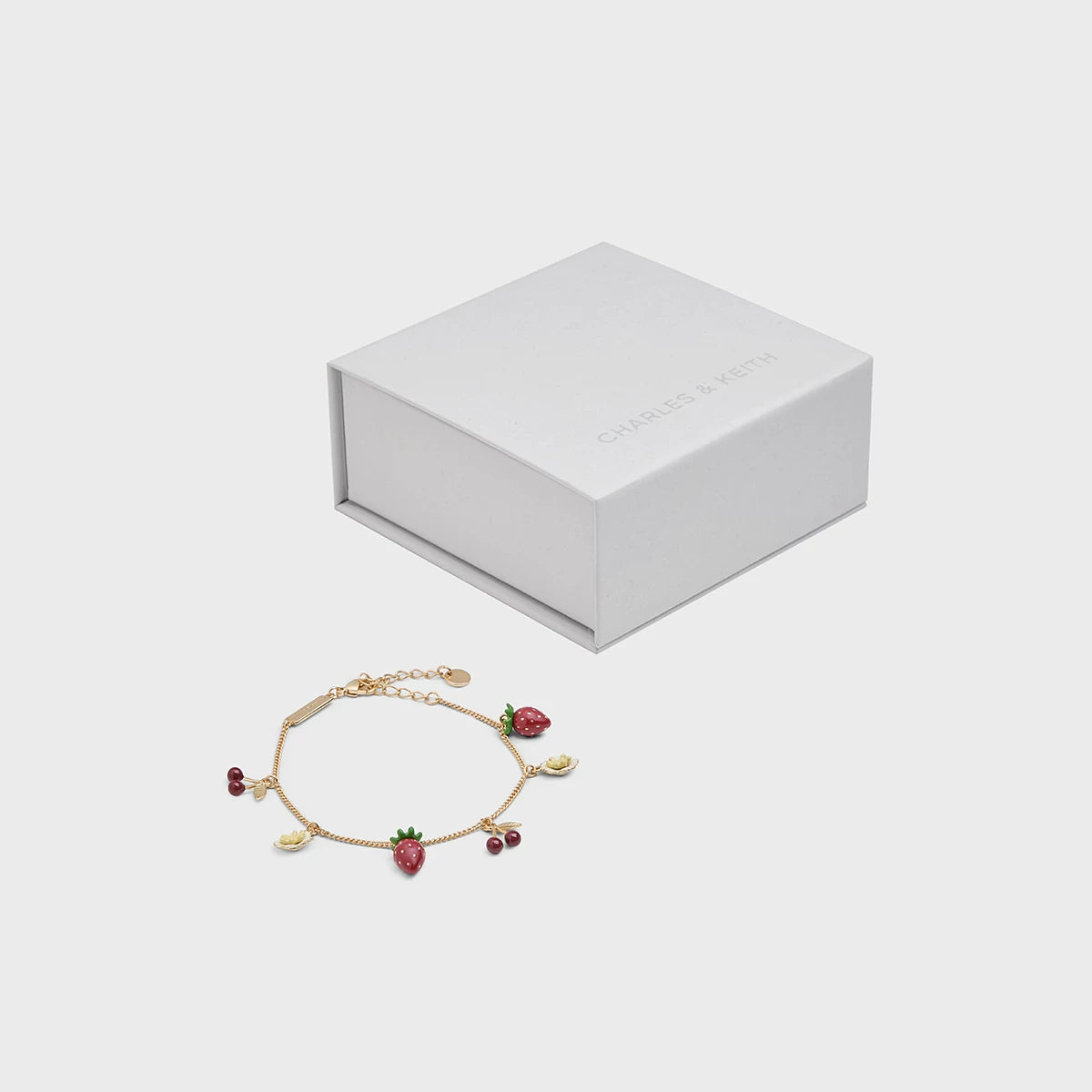 سوار نسائي من Charles & Keith بتصميم الفواكه الذهبي.