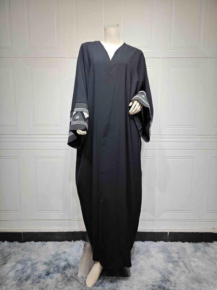 Elegant black abaya with wide embroidered sleeves, featuring geometric patterns, perfect for formal occasions.