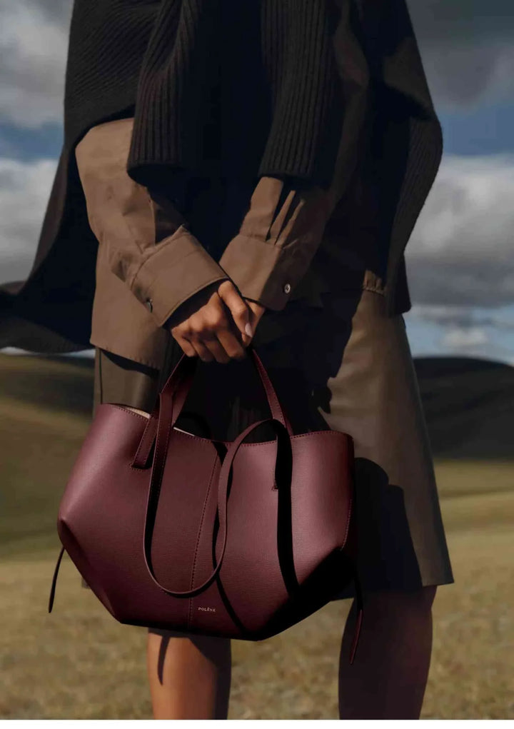 Polène Cyme Mini small tote bag in maroon leather with smooth curves, dual open or closed flower design, handmade in Spain.