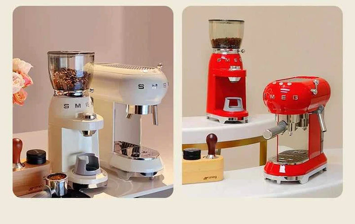 SMEG coffee grinder in ivory and red with transparent bean hoppers and stainless steel accents on kitchen countertop