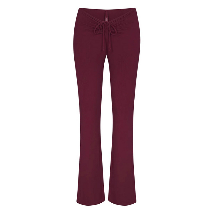 SKIMS wide leg lounge pants in burgundy with adjustable drawstring waist, soft stretchy fabric for casual comfort.