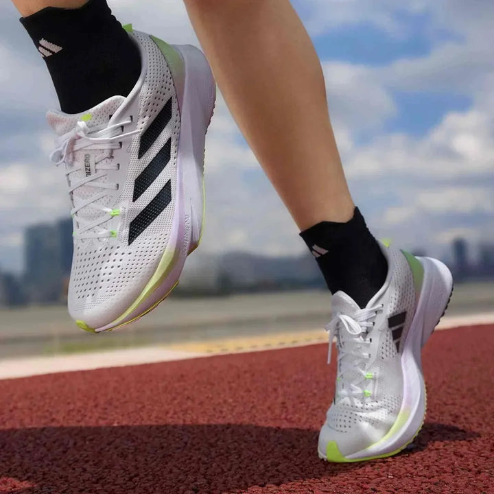 حذاء جري أديداس ADIZERO SL أبيض مع خطوط سوداء ونعل صلب مناسب للرجال والنساء على مضمار الجري.