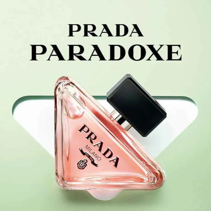 PRADA Paradoxe women's luxury perfume with pink triangular bottle and black cap on soft green background