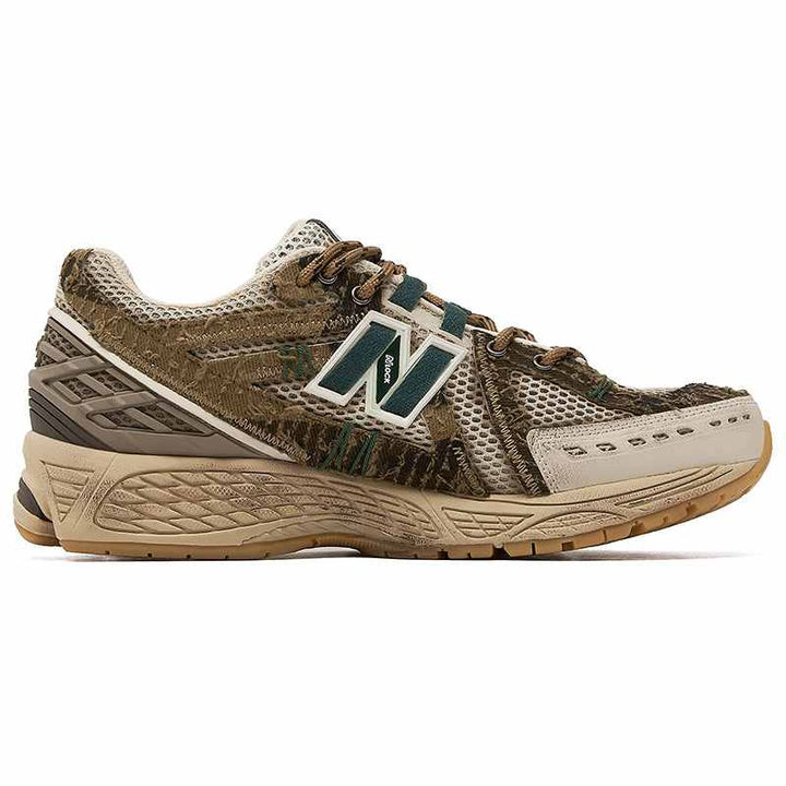 New Balance 1906R sneaker in earth tones with camouflage pattern, mesh and leather materials, designed for comfort and durability in limited edition.