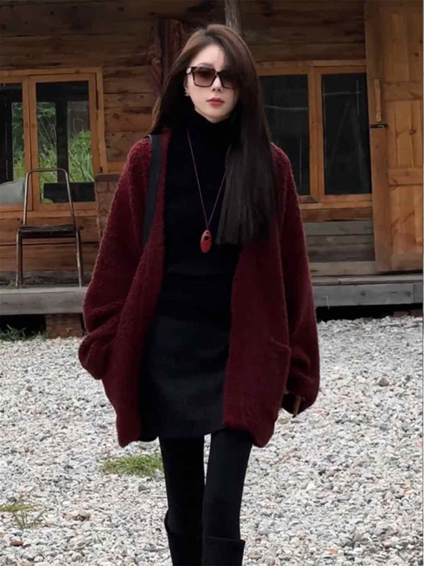 woman wearing burgundy long wide winter cardigan with pockets and black outfit outdoors