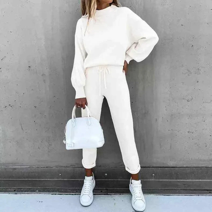 Wide-sleeve tracksuit with waist tie in white, paired with white sneakers and bag.