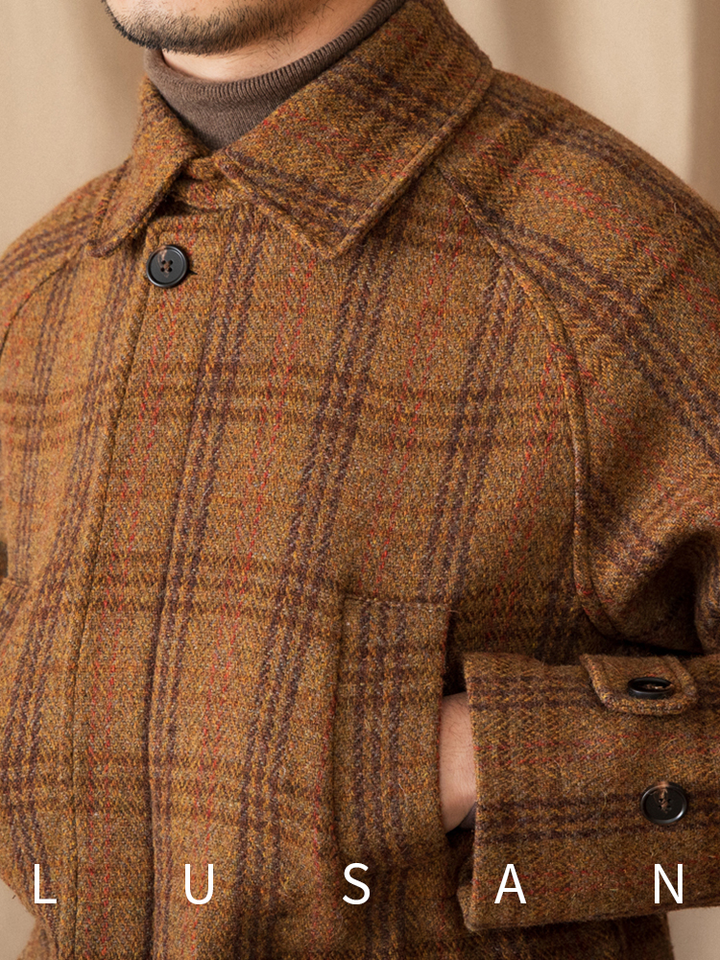 Close-up of Mr. Lusan hunting tweed jacket in warm brown and orange plaid wool fabric with buttoned cuff and collar details