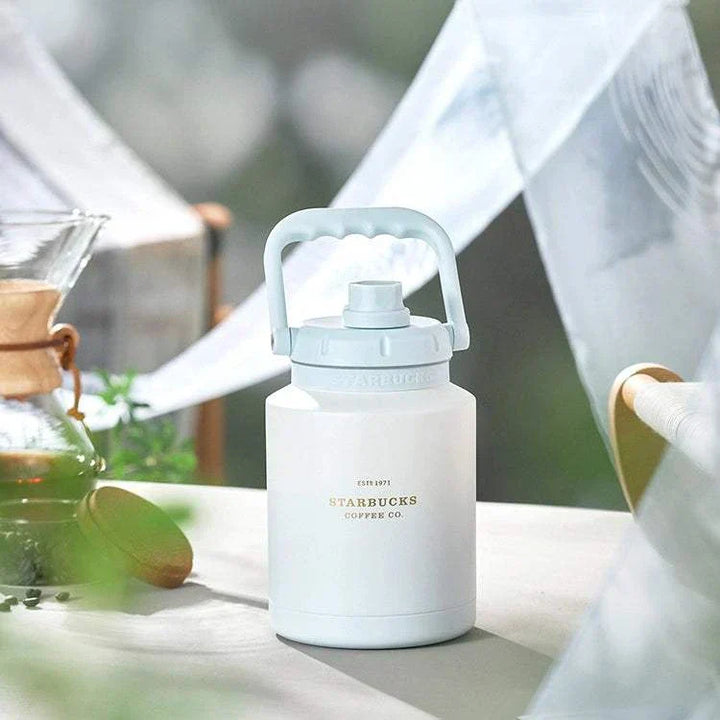 كوب ستاربكس موديل كيرينو أبيض مع غطاء أزرق فاتح وعزل حراري تصميم عملي وأنيق