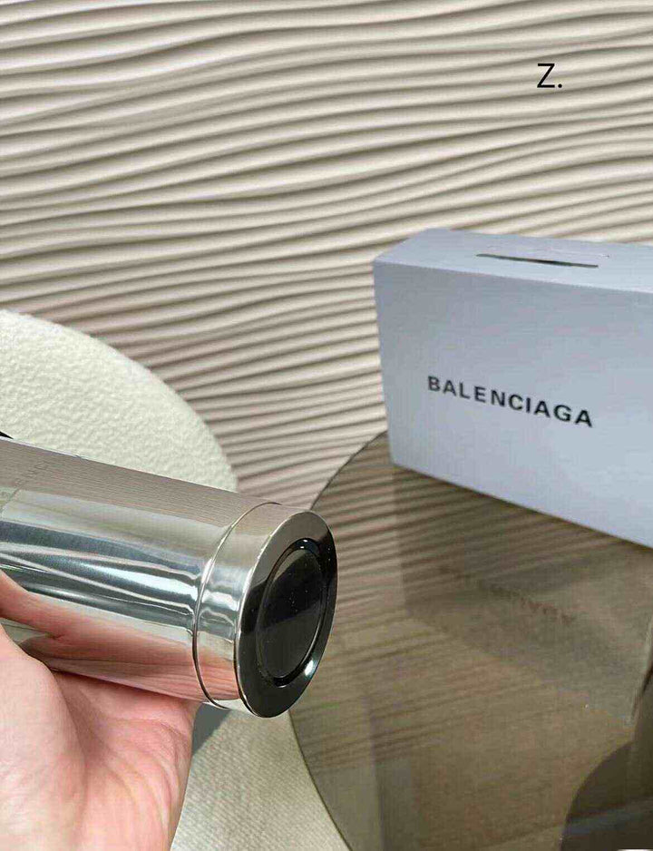 كوب ستانلس ستيل Balenciaga فاخر مع شعار محفور ولمعة معدنية جاذبة.