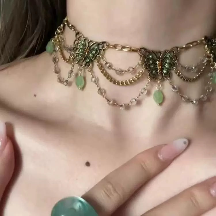 قلادة Choker بتصميم فراشات ذهبية وأحجار باللون الأخضر.