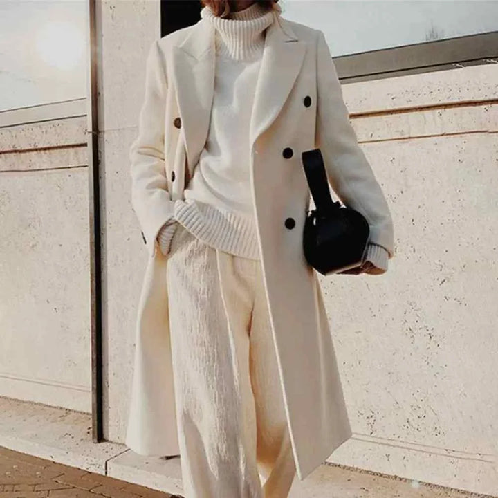 classic winter coat with double-breasted buttons in elegant beige color, styled with cozy turtleneck sweater and light trousers